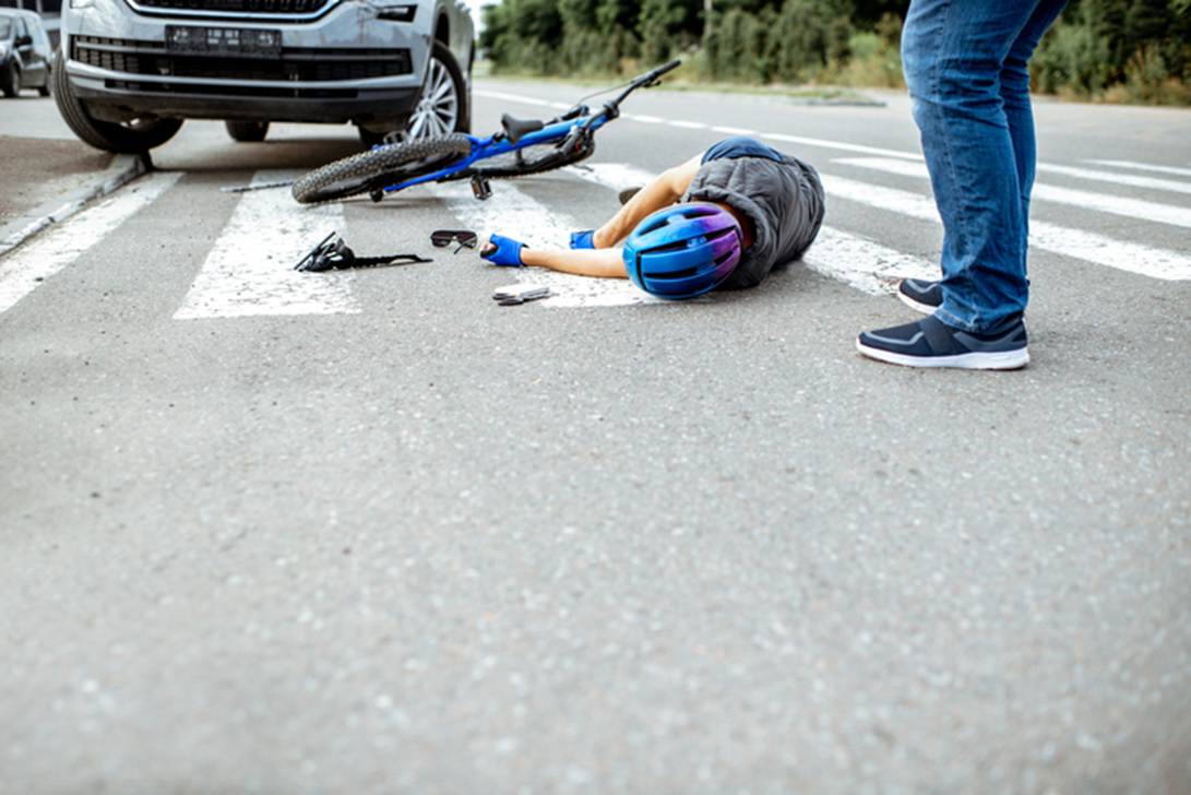A person lying on the ground next to a bicycle
AI-generated content may be incorrect.